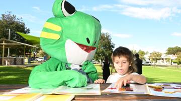 HIPPY mascot, Flip Flop the Frog, helps current HIPPY youngster Jaxon Webster learn to sound out words. Picture by Peter Hardin