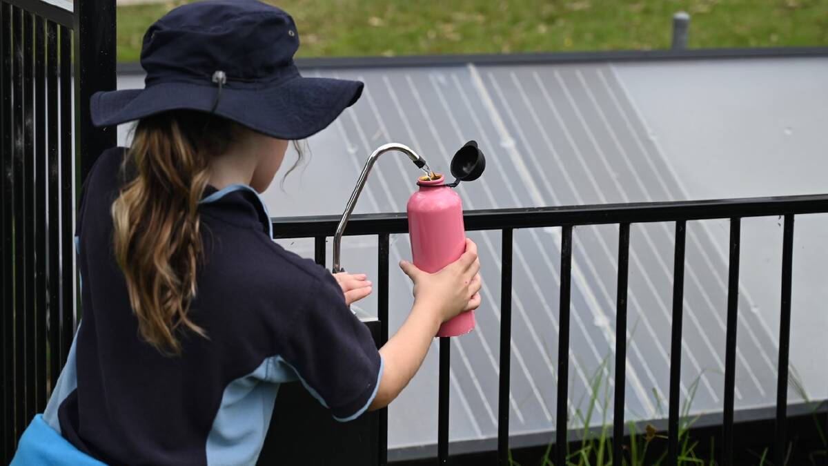 A student at Cobargo public school collecting rainwater developed by SOURCE technology. Drummond Public School is Armidale was one of 10 schools in NSW that participated in the drinking water trial which has been deemed a success. Photo supplied 