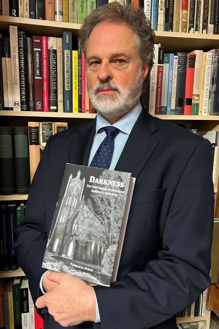UNE professor Thomas Fudge holding his new book, 'Darkness: The Conversion of Anglican Armidale 1960-2019'. Picture supplied