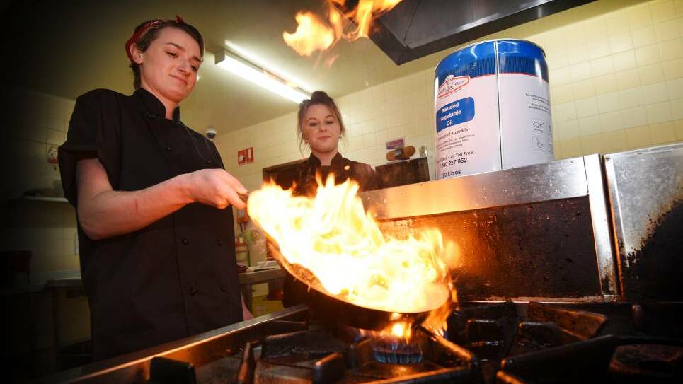 SIZZLING: Wests Diggers head chef Hayley Fisk and fellow chef Shenae Rekstad cooking up a storm with a healthier oil in the pans and fryers which will cut a huge amount of fat from their dishes. Photo: Gareth Gardner 190717GGB02