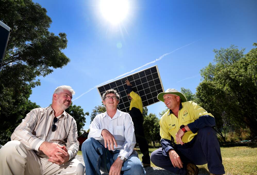 SUNNY SIDE: Adam Blakester, Graeme Harris and Eco Energy and Solar Solutions director Brett Martin watch the panels get installed. Photo: Gareth Gardner 021216GGB02
