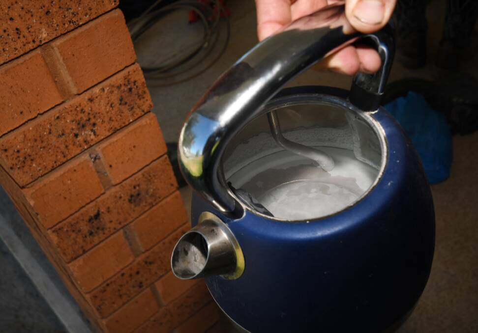 HARD WATER: A resident shows the inside of a kettle, riddled with calcium. Photo: Gareth Gardner