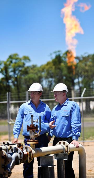 HOT TOPIC: Santos' Todd Dunn and Peter Mitchley at the Narrabri Gas Project, with a flare going off in the background. Photo: Geoff O'Neill 050215GOA08