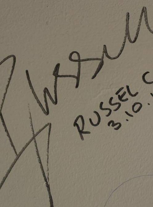Wall-of-fame: Actor Russell Crowe adds his name to the Courthouse Coffee shop wall on Monday morning.