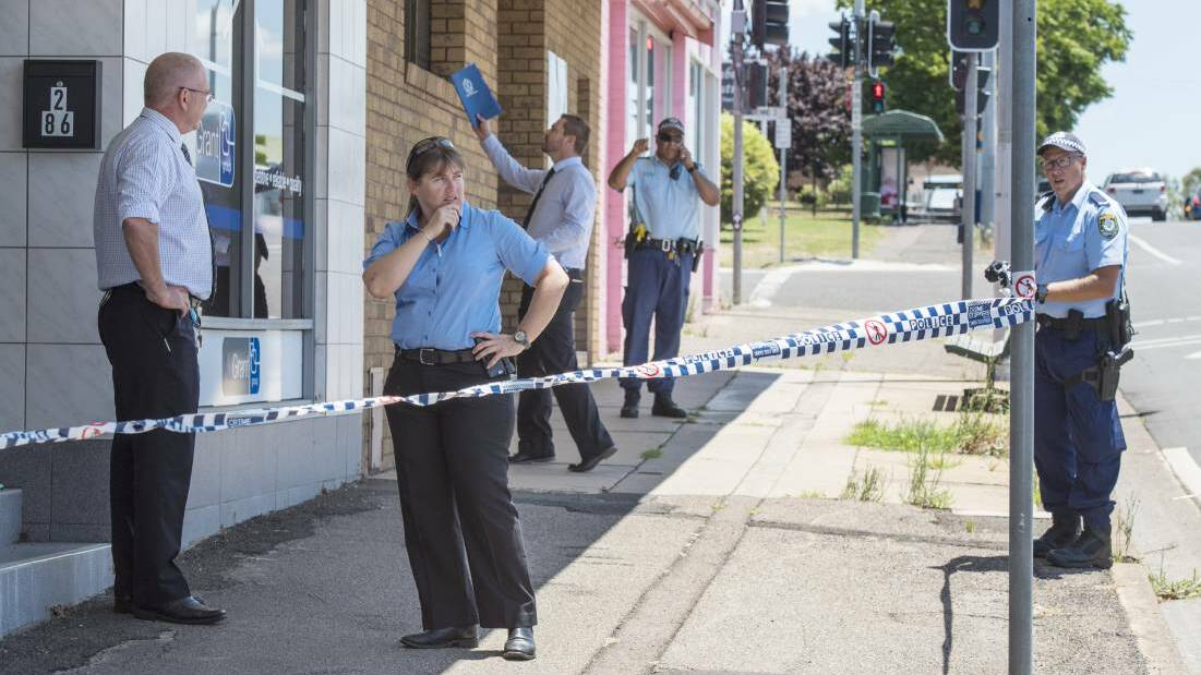 Taking a toll: Oxley detectives comb a crime scene in Tamworth. Photo: Peter Hardin
