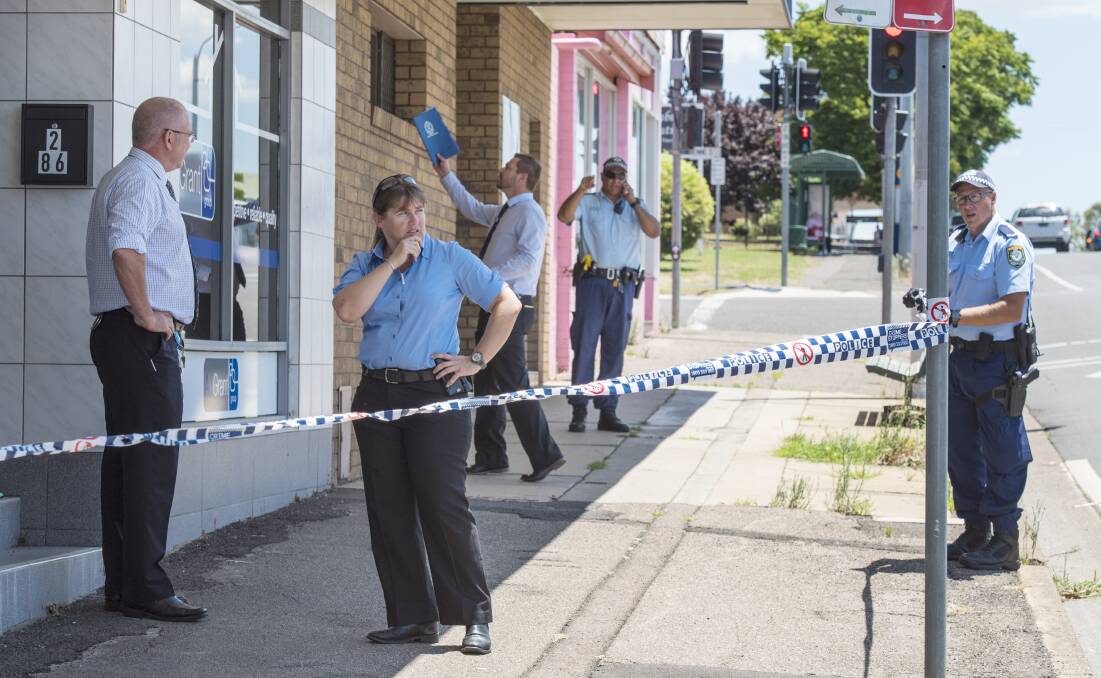 Crime scene: Oxley detectives and police comb the scene after a shot was fired into a Tamworth shopfront on Bridge St. Photo: Peter Hardin