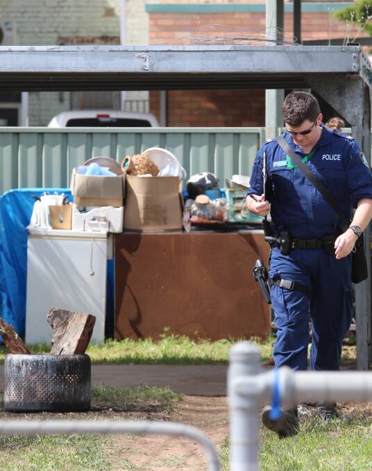 Crime scene: A police forensics officer combs the backyard of the Little Barber St home in Gunnedah where the explosion occurred. Photo: Sam Woods