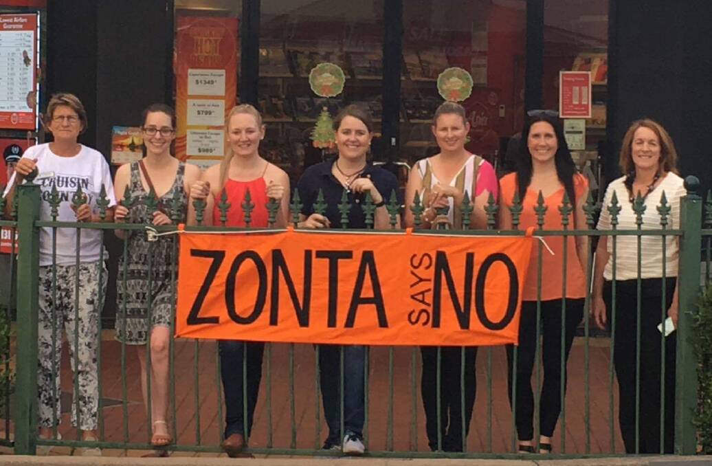 Orange zone: Zonta Club of Tamworth members unveil one of the campaign's banners on the corner of Peel and White Street as part of 16 days of action.