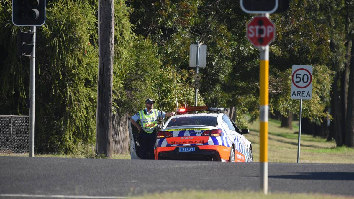Lights out: A highway patrol officer arrives at the intersection of Ebsworth and Bridge Streets to help direct traffic. Photo: Gareth Gardner 