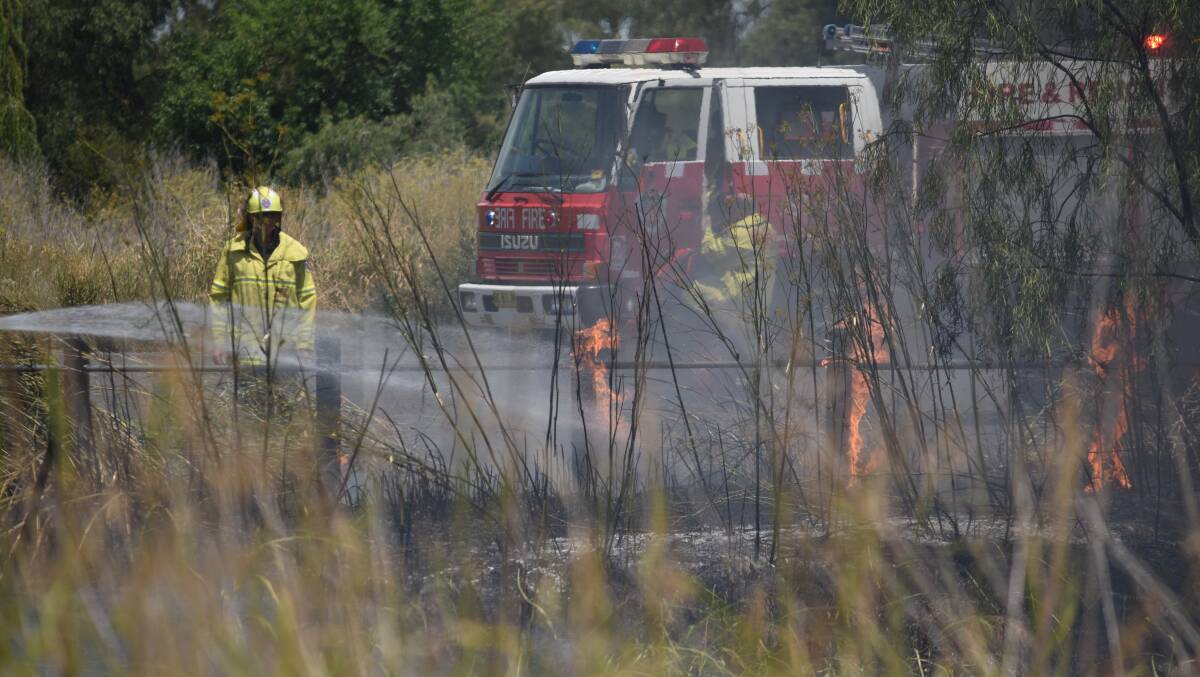 Crews quickly got to work to extinguish the small fire near the Gipps Street fields. Photos: Ben Jaffrey