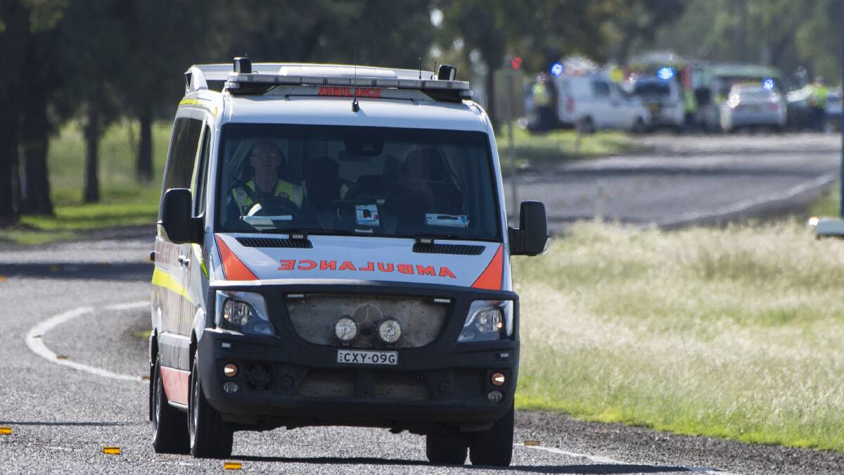 Crash scene: An ambulance leaves the fatal crash on the Oxley Highway, near Tamworth, with one of three patients on board. Photo: Peter Hardin 310317PHC027
