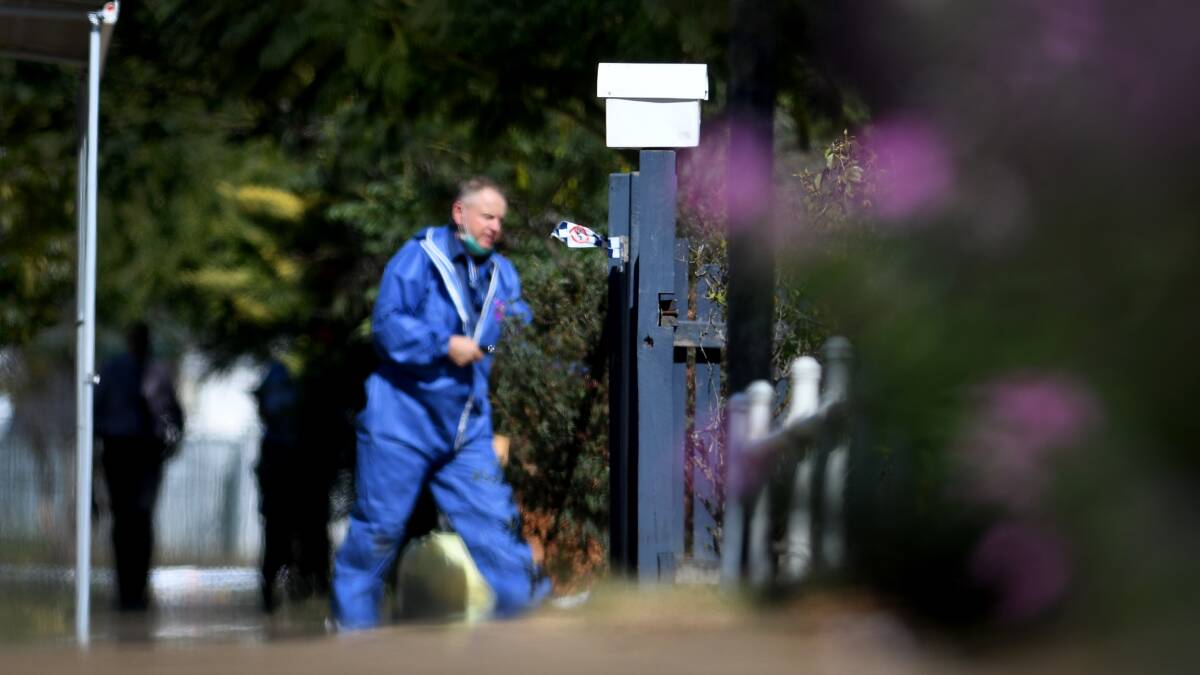 Crime scene: A forensic policeman in Robert Street as officers canvassed the neighbourhood on Thursday. Photo: Gareth Gardner