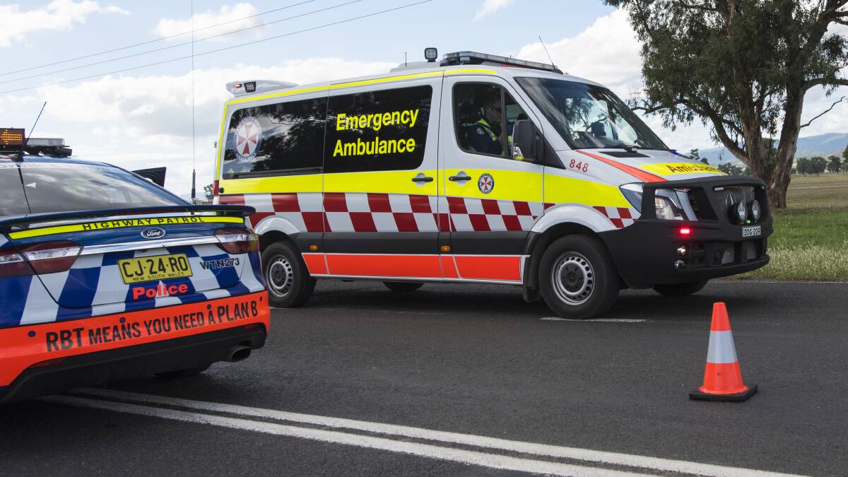 Crash scene: An ambulance leaves the fatal crash on the Oxley Highway, near Tamworth, with one of three patients on board. Photo: Peter Hardin 