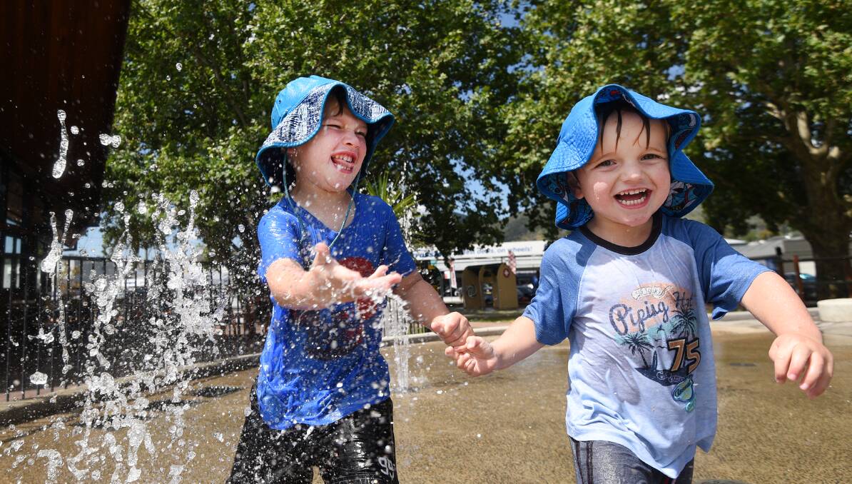 Heat is on: Brandon Smith, 5, and his three-year-old brother, Jaydon, cool off at the Tamworth Regional Playground on Friday. Photo: Gareth Gardner 