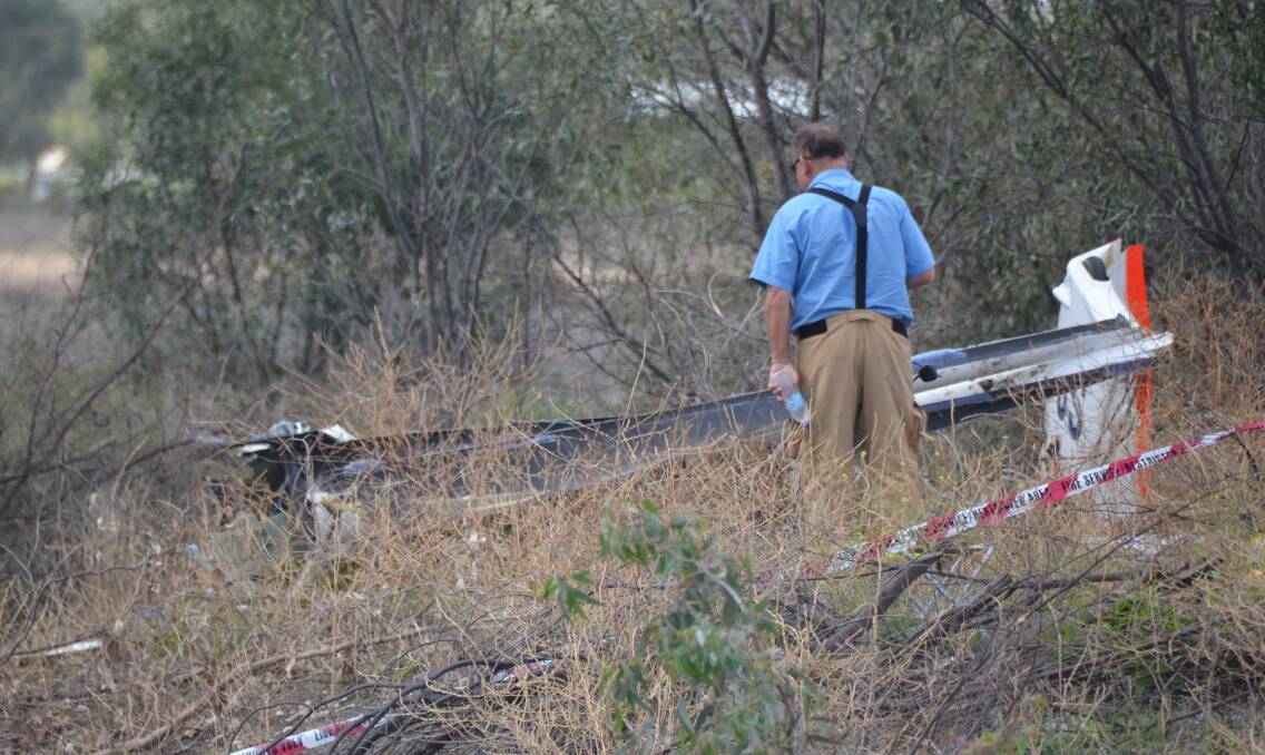 Crash scene: An investigator examines the site where the glider crashed near Boggabilla on Monday.
