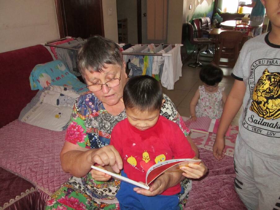 LOVE OF BOOKS: Linda and 12-year-old Xiao Lin, a little boy with special needs whose parents brought him to the orphanage. Linda says she and Xiao Lin, whom she named, have a special bond.