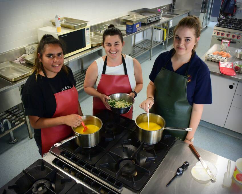 FAST SELLER: Tayla Powell, Irem Mooney and Charlotte Baker make their dish for the Oxley High School international food night. Photo: Carolyn Millet 220318CMA01