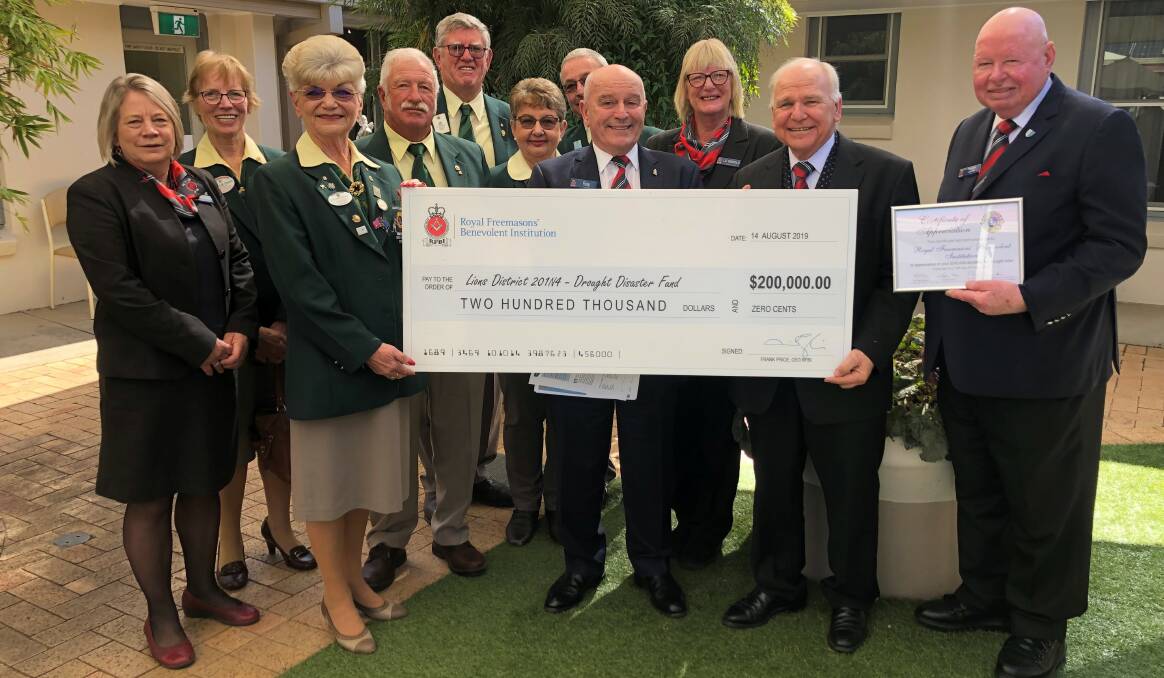 Big big cheque: Lions Club and RFBI representatives were pleased to be able to join forces to help alleviate the suffering of people on the land. Photo: supplied