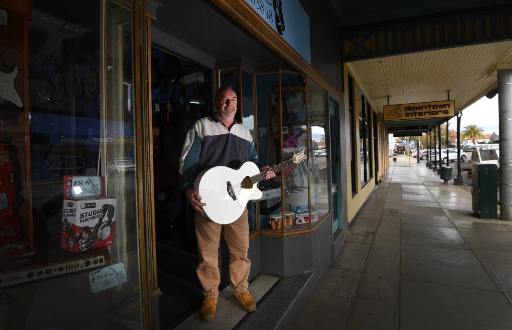 COMMUNITY IN TUNE: Ash Hawken of Capitol Music with the guitar that was stolen and recovered within less than 24 hours. Photo: Gareth Gardner 190717GGC01