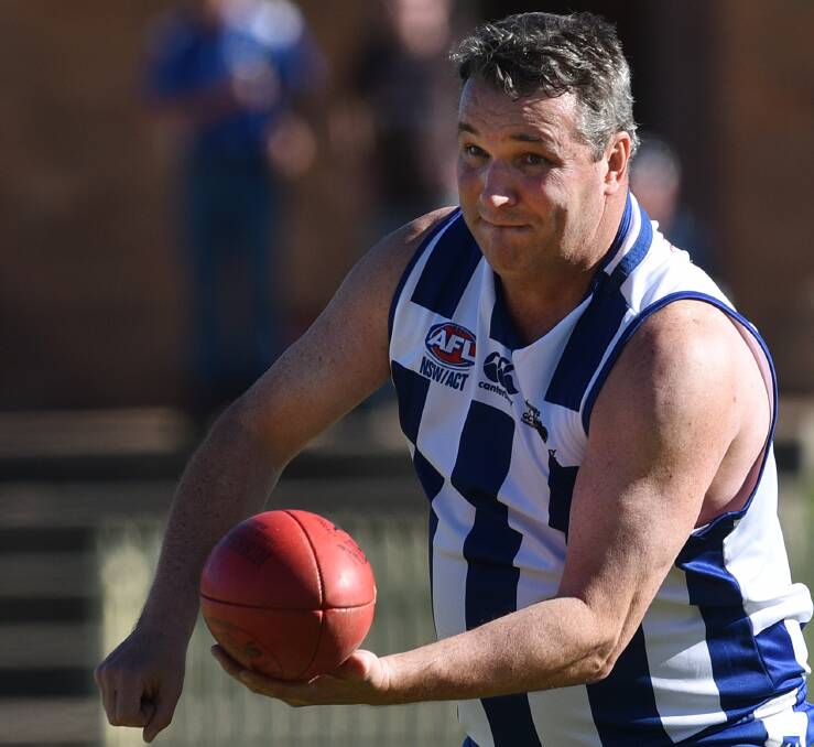  Veteran: Roos Vince Woodgate handballs to support in the big win over local derby rivals the Swans.  
