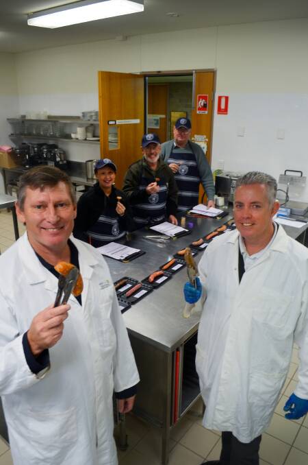 Sausage samplers: Steve Fleming and Craig Wright hold up some finished products for judges Justine Young, Tony Jackson and Wal Hayden. Photo: Chris Bath