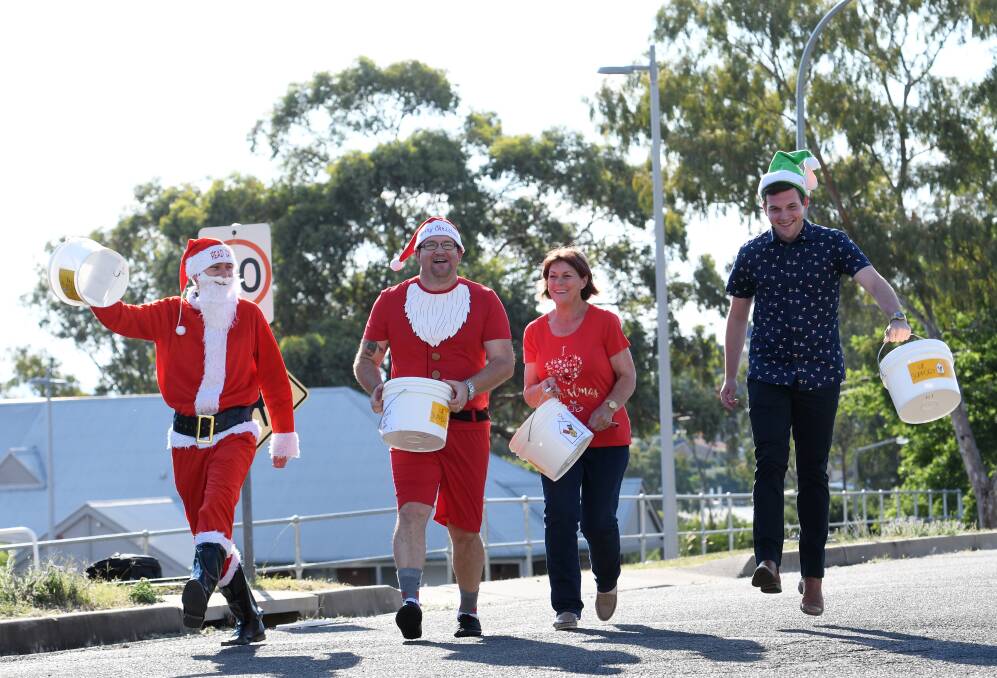 You better watch out: Chris Watson, Josh Howison, Sue Williams and Jeremy Boyle warm up the donation buckets for the annual Santa Crawl.  Photo: Gareth Gardner 
