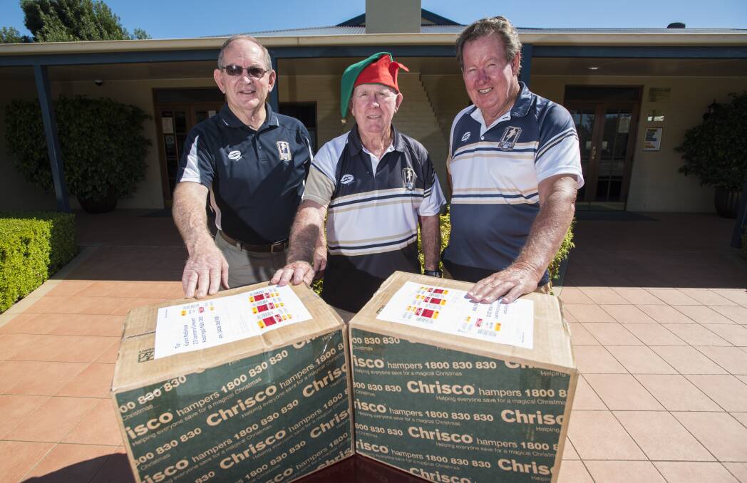 Christmas cheer: Men of League members Ken Thompson, Kevin Robinson and Peter Woolaston with two of the Chrisco hampers. Photo: Peter Hardin 221216PHA007