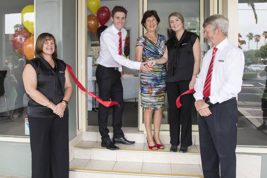Open for business: Sam and Katelyn Spokes cut the ribbon on their new venture with deputy mayor Helen Tickle, while Leanne and Alan Spokes watch on at the new LJ Hooker office on Peel street. Photo: Peter Hardin