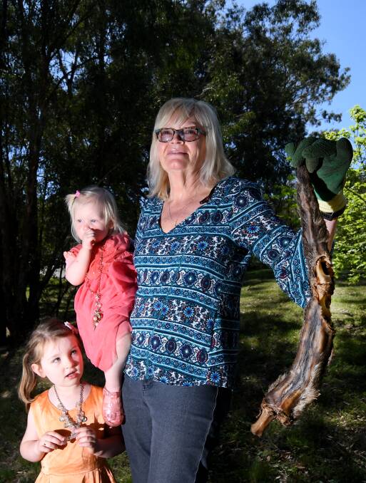Mysterious tail: Leone Clark removes another kangaroo tail from her yard on Armidale Rd with granddaughters Cadence and Gwen. Photo: Gareth Gardner