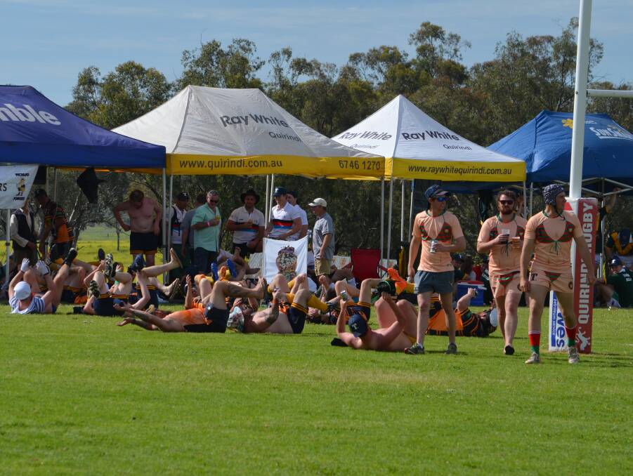 Great day: Three Albies Old Boys show off their bikini bodies as they cross the field in front of another side practicing a traditional touring rugby dance.