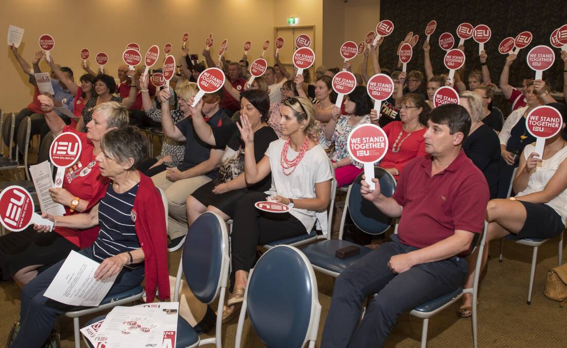 Hands up: Tamworth's Catholic teachers banded together at Monday's strike to protest an enterprise bargaining agreement they believe has left them without access to the Fair Work Commission. Photo: Peter Hardin