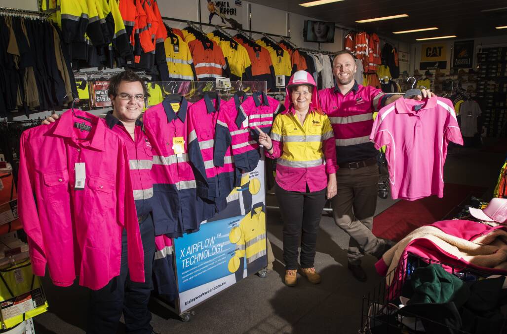 Pink professionals: Hip Pocket Workwear's Bradley Laws, Sue McIntosh and Michael Gay with just some of the available Tradies Support The Ladies' work wear for Pink Fridays, which has taken off. Photo: Peter Hardin 081217
