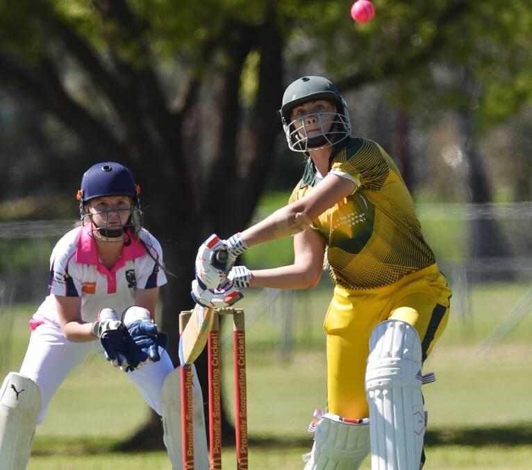 Line it up: North Coast's Chloe Saunders looks to blast this ball to the boundary as Riverina keeper Paris Crelly looks on in the final. Photo: 280916GGE03