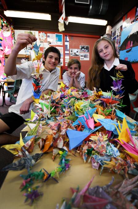 Cranes for a cause: Charlie Hazlewood, Aston Jeffrey and Maddi Smith-Hall have been keeping busy, folding over 1000 paper cranes for Hiroshima. Photo: Gareth Gardner