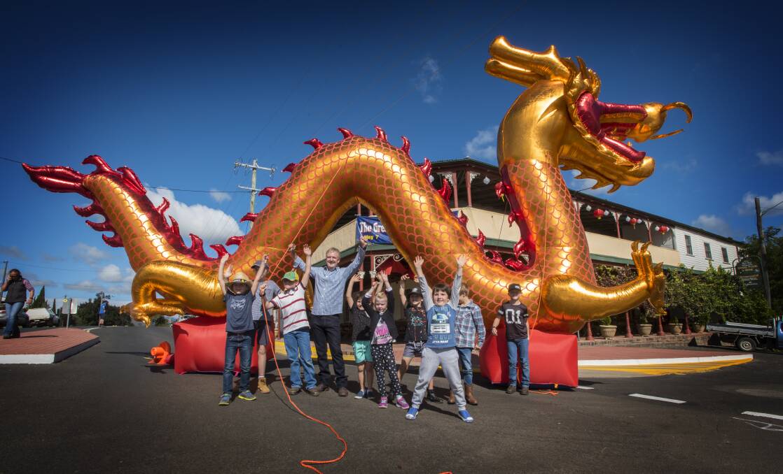 Enter the dragon: Festival chairman Nick Bradford and some local Nundle kids hail the great golden dragon of the Go for Gold Chinese Festival. Photo: Peter Hardin 130417