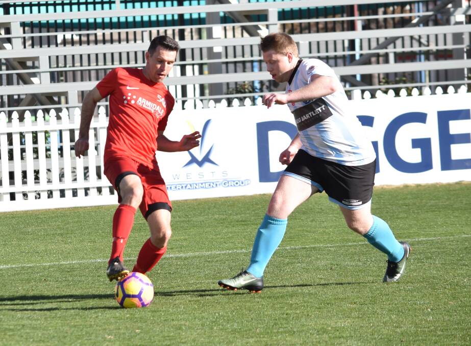 CONTEST: Norths United's Michael Griffith holds possession as Tamworth FC's Sam Williams closes in. Photo: Ben Jaffrey