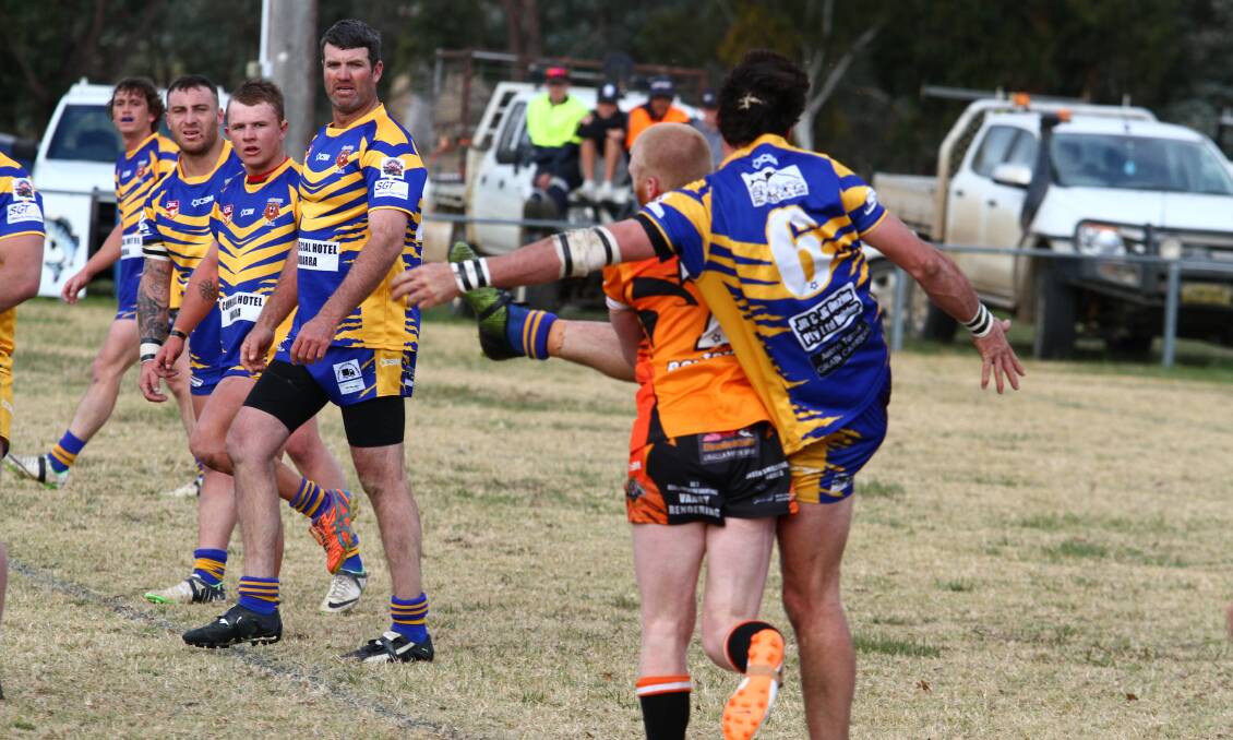 RINGSIDE: Tigers halfback Kearin Stiff and Bears five-eighth Todd Cleal get tangled up as a line of Bundarra players look on.