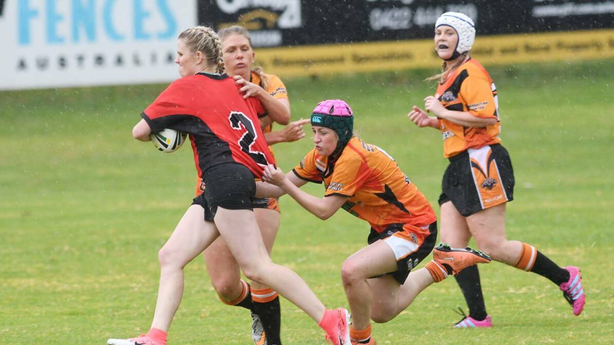 PROWLING: Tigers players Ella Elks, left, and Danielle Sutton work to bring down a North Tamworth attacker on Saturday, as Hannah Skewes looks on. Photo: Gareth Gardner 