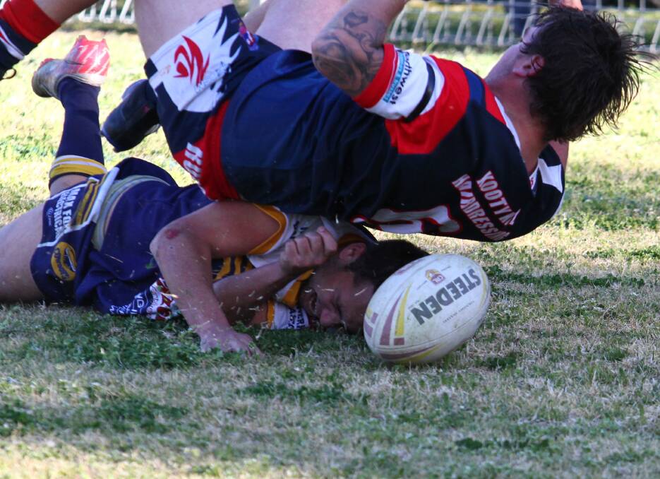 TIGHT FIT: Pint-sized Cowboys pivot Dale Wood managed to squeeze under his opposition number, Jordan Sharpe, to score this improbable try. Photo Mark Bode 