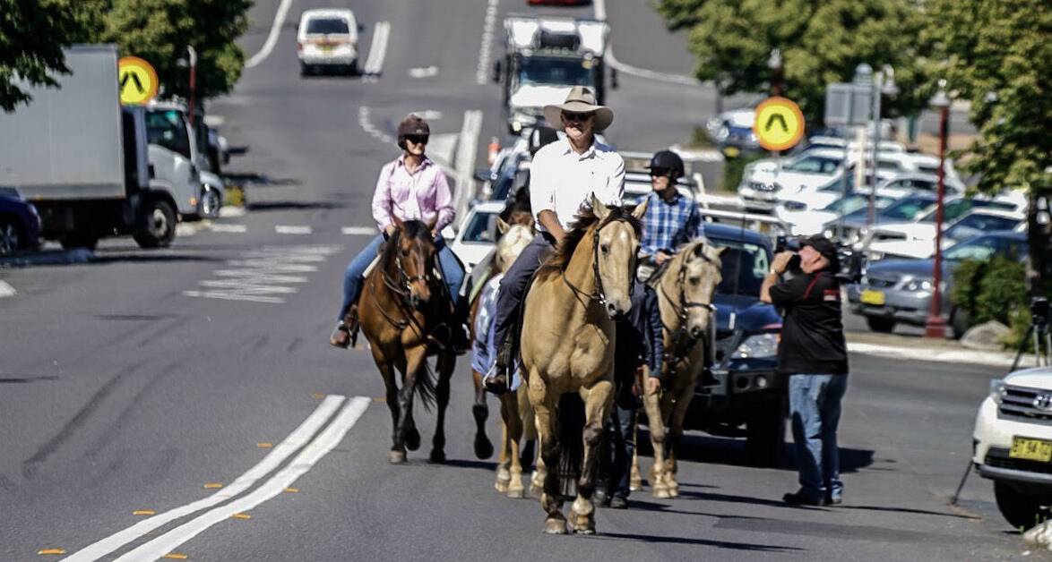 FARMERS RALLY: Four farmers from across the region take the reins in a street protest on climate change in Uralla on Thursday morning.