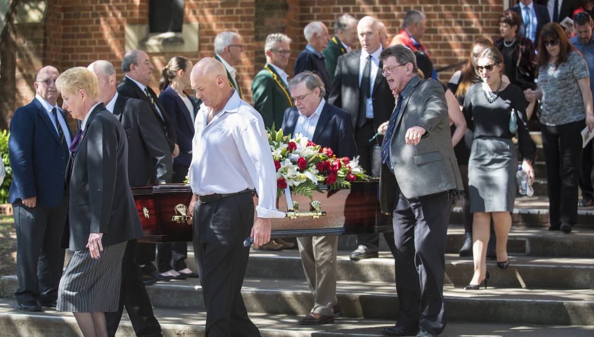FAREWELL: John Gleeson is carried out by family as cricket luminaries and lawn bowling mates form a guard of honour. Photo: Peter Hardin
