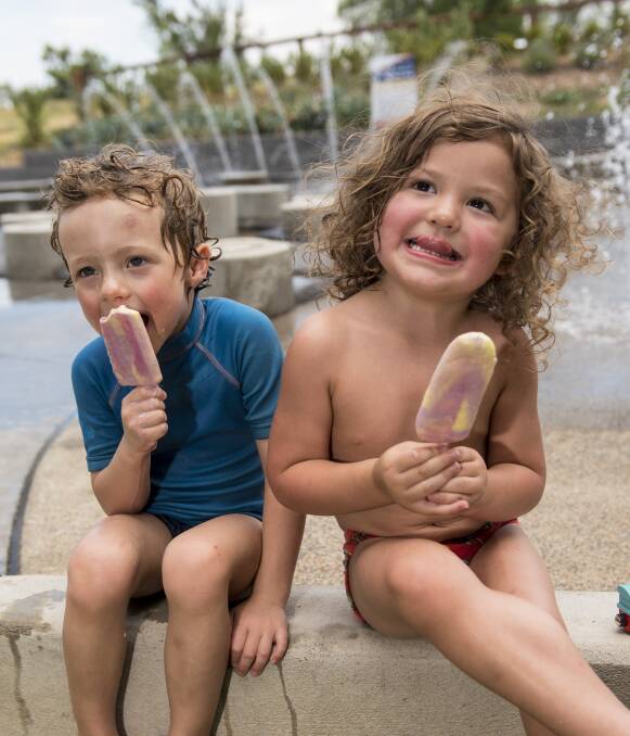 BEAT THE HEAT: Charlie Williams and Aiden Beacroft Schan chill out with an ice-cream  during the heatwave in Tamworth on Monday. Another scorching day is forecast for Tuesday. Photo: Peter Hardin 051216PHA039