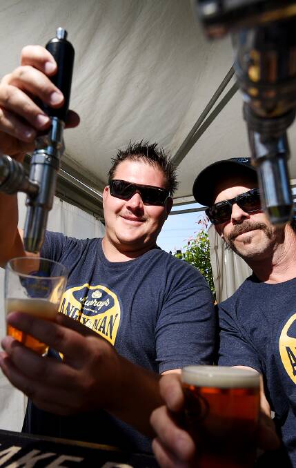 THIRST QUENCHERS: Adam Groober and Scott Taylor pour some beers at Brewfest at Scully Park on Saturday afternoon. Photo: Gareth Gardner 191116GGG02