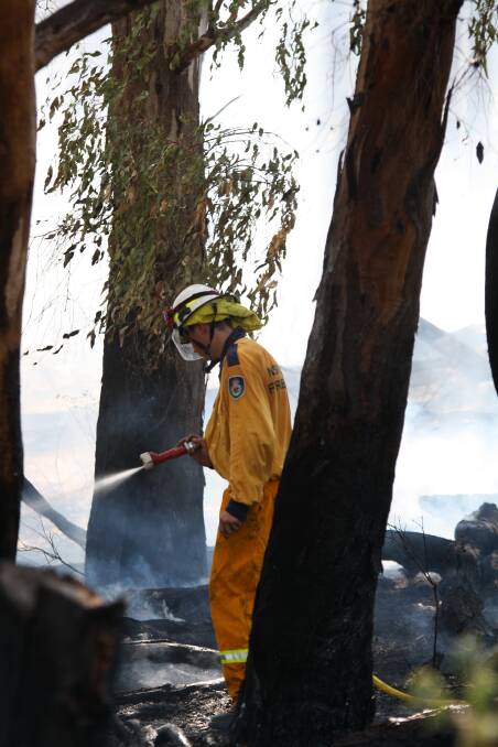Jordan Lodge, of Gunnedah RFS, extinguishes a blaze at Cushan's Reserve. Photo: Sam Woods