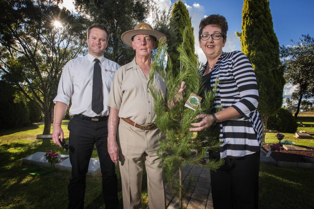 Paul Brooks, Father Tom Shanahan and Margaret Tarbert plant a Lone Pine tree. Photo: Peter Hardin