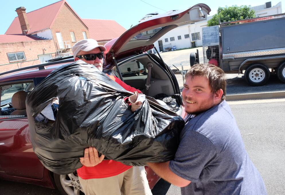 TAKES A VILLAGE: Peter Campbell and Phillip Minty from Connections unloading part of the overnight donations made to the BEST Community Shed bins. 