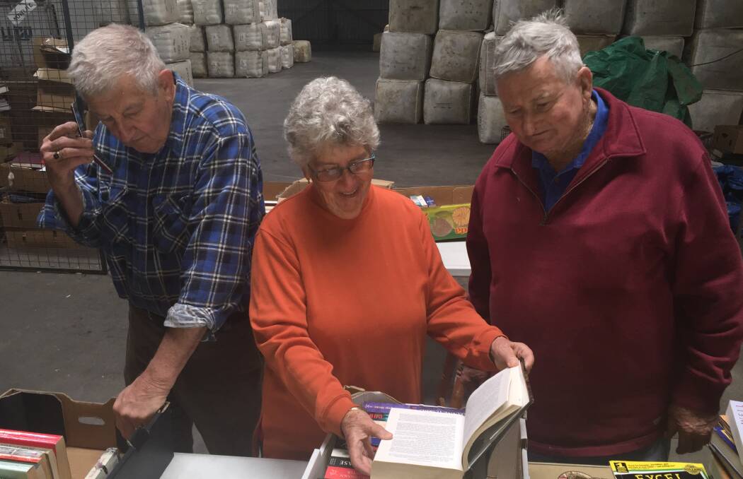 So many books: plenty of bargains. Bill and Margaret Bottom and Rotarian Bruce Ditchfield find the books that will attract attention. Photo: Merilyn Vale
