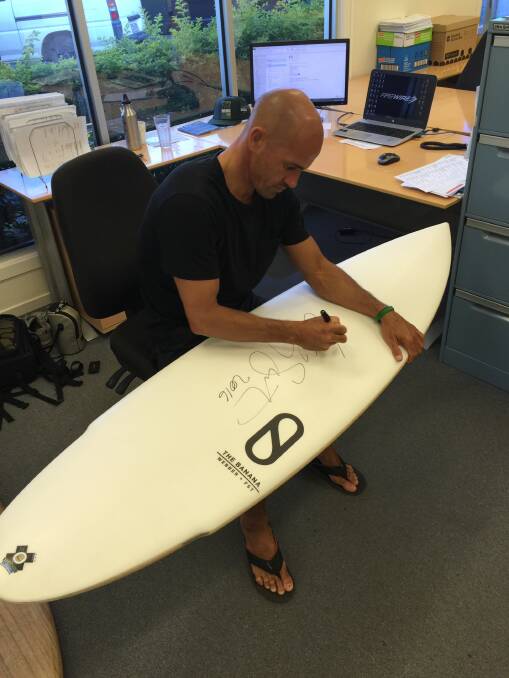 Kelly Slater signs a board intended for Brett Connellan's fundraiser. Source: supplied