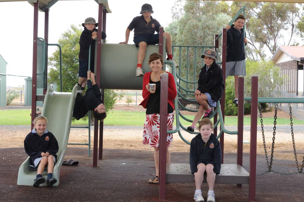 Booligal Public School principal Linda Stewart with students in an earlier year. There is a steady stream of new students to the school, but not a steady stream of internet capability. 