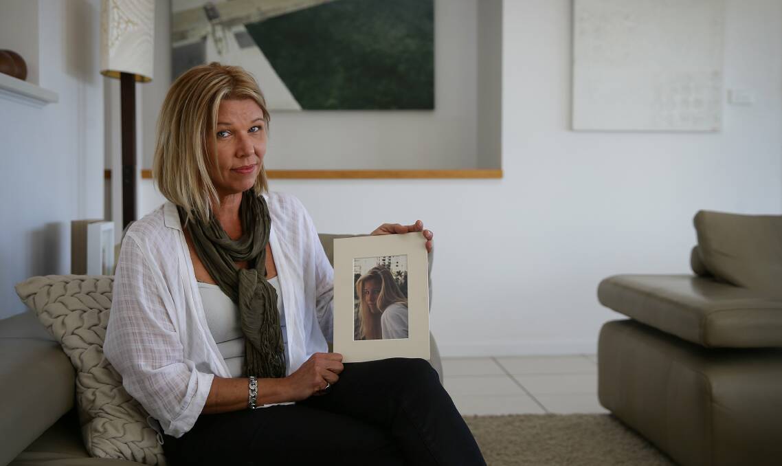 THE LOSS: Rachael Keenan holds a photograph of her little sister, Sarah Mahony, who was killed in a car crash on Burwood Road, Whitebridge, when she was 15 years old. 